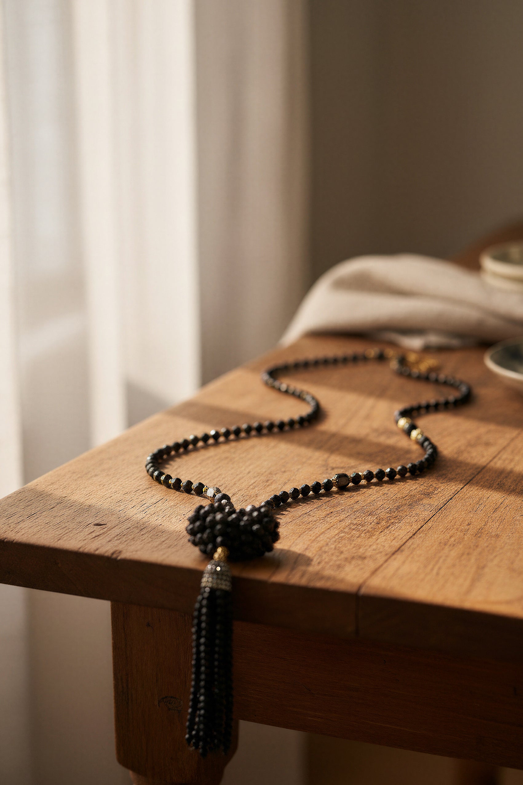 Lange schwarze Glasperlenkette mit funkelndem Herz und Steinchen-Quaste