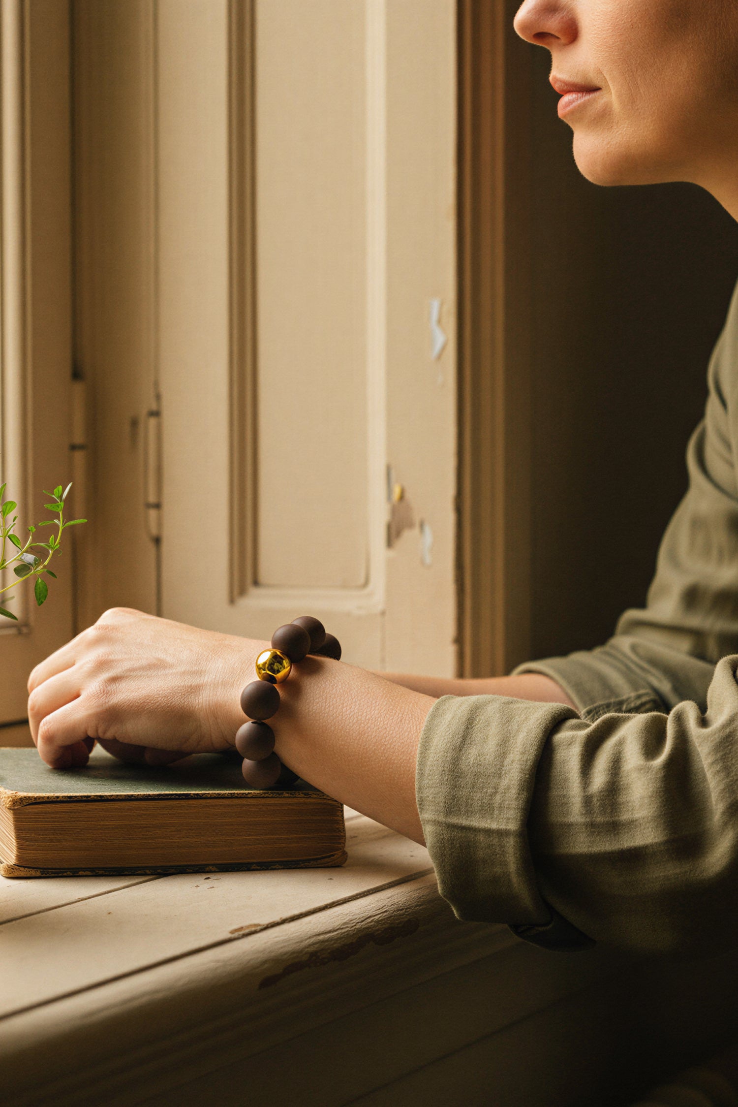 Armband aus Acryl in Dunkelbraun mit Goldkugel